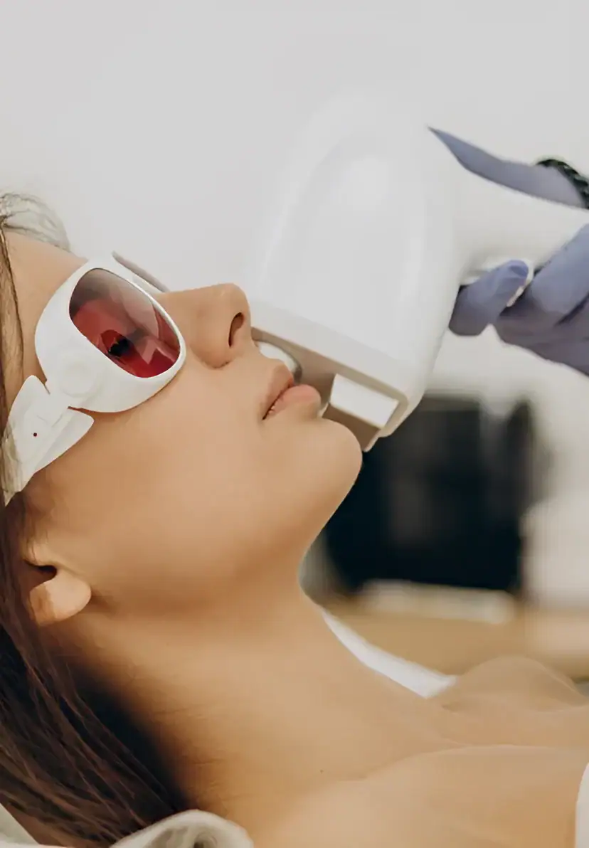 IPL laser skin treatment being performed on a woman's face in a clinical setting.