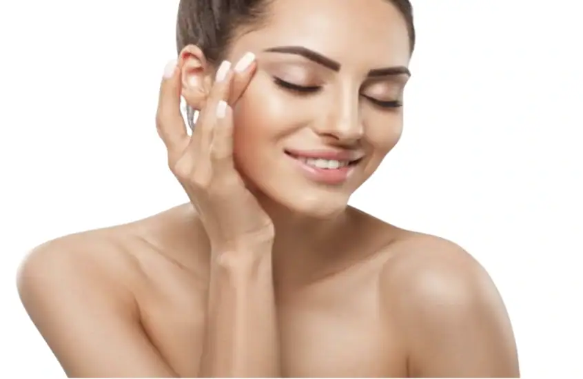 A woman with clear skin smiling gently, touching her face with her hand.