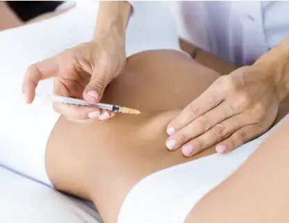 Intravenous injection being administered to a patient's thigh.