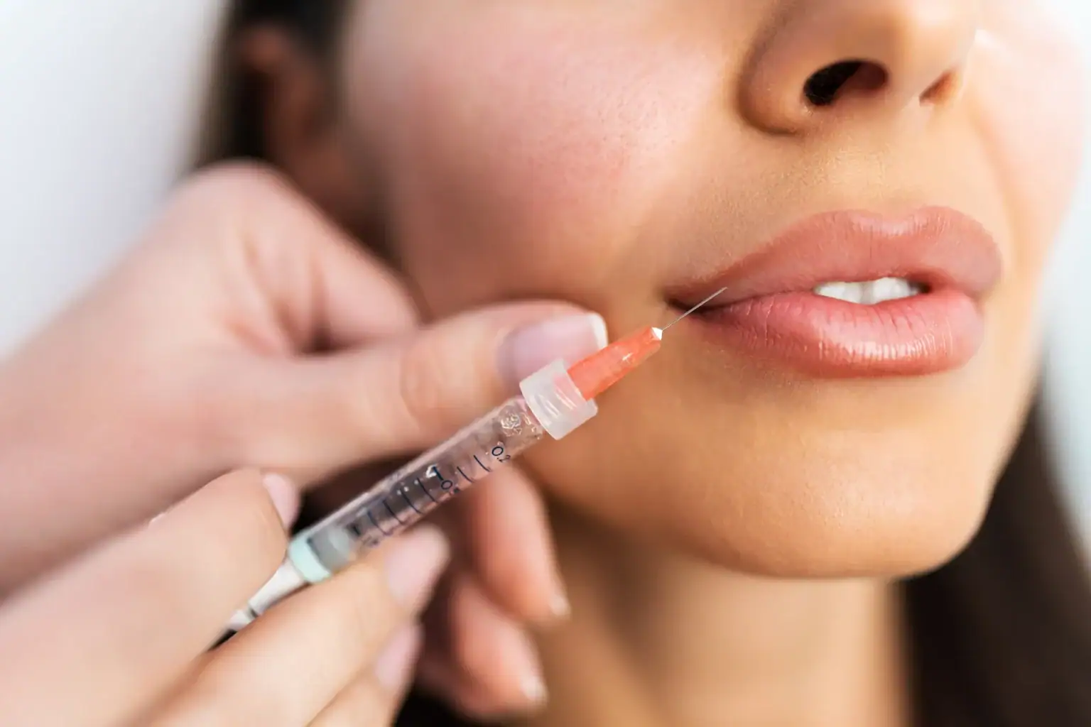 A woman receiving lip filler injection from a healthcare professional.