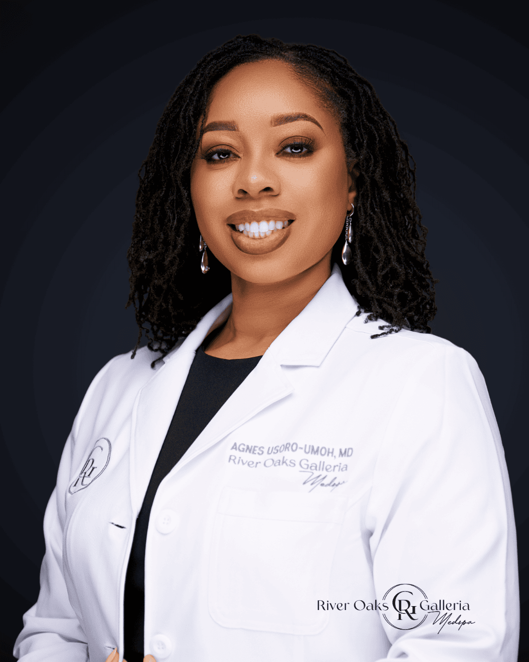 Female medical professional in white coat smiling, with dark background.