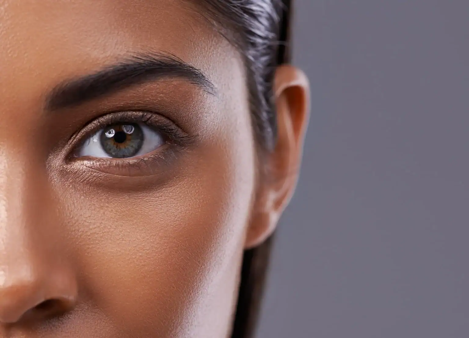 Close-up of a woman's eye showing smooth skin and well-defined eyebrow.