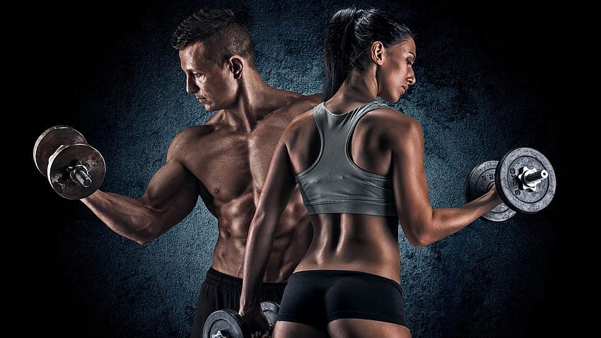 Duo of fit individuals lifting dumbbells during workout.